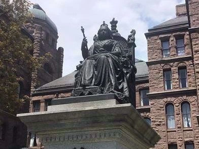 Monument de la Reine Victoria tenant un sceptre, signe de royauté.