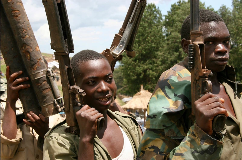 Anciens combattants africains transportant des armes.