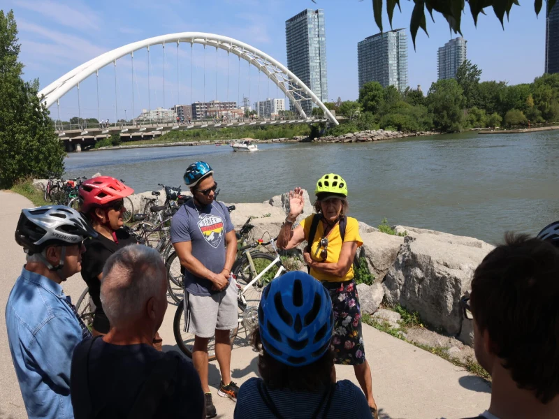 La guide Rolande Smith entourée de cyclistes attentifs, près de la rivière Humber.